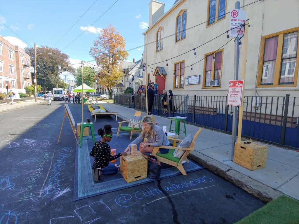 Two people play a game at the Allston Village Street Fair