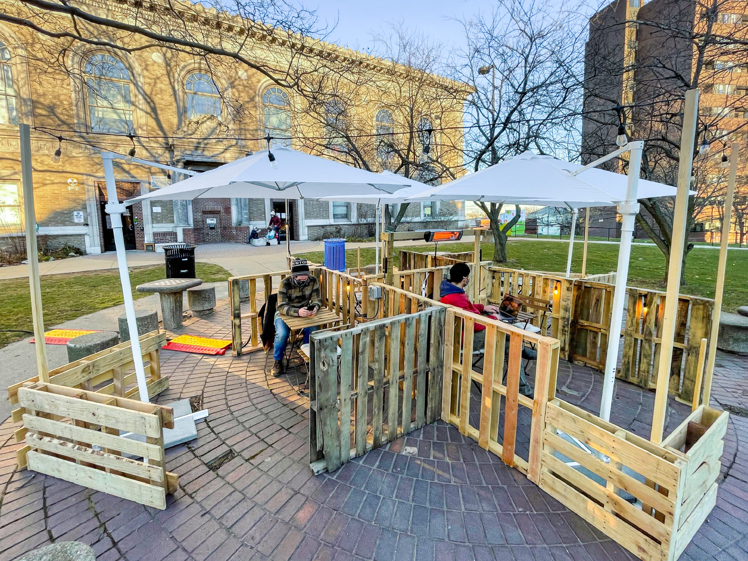 Pallets, umbrellas, and chairs make a outdoor seating area in the courtyard of the Somerville Public Library