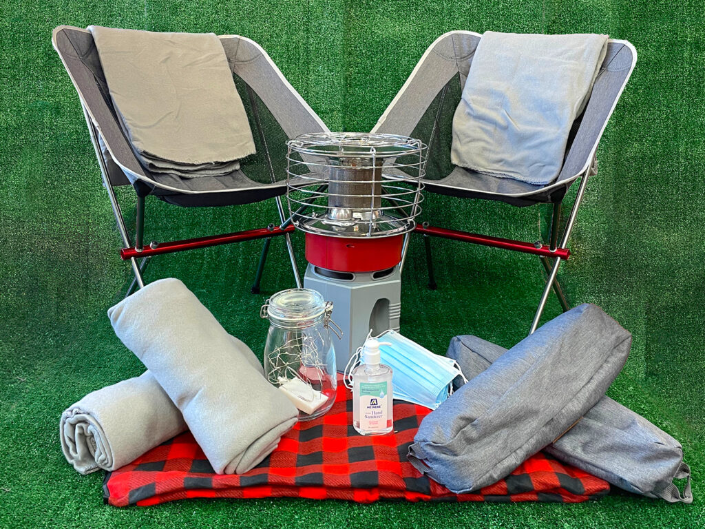 A chair, heater, and light against a green turf backdrop