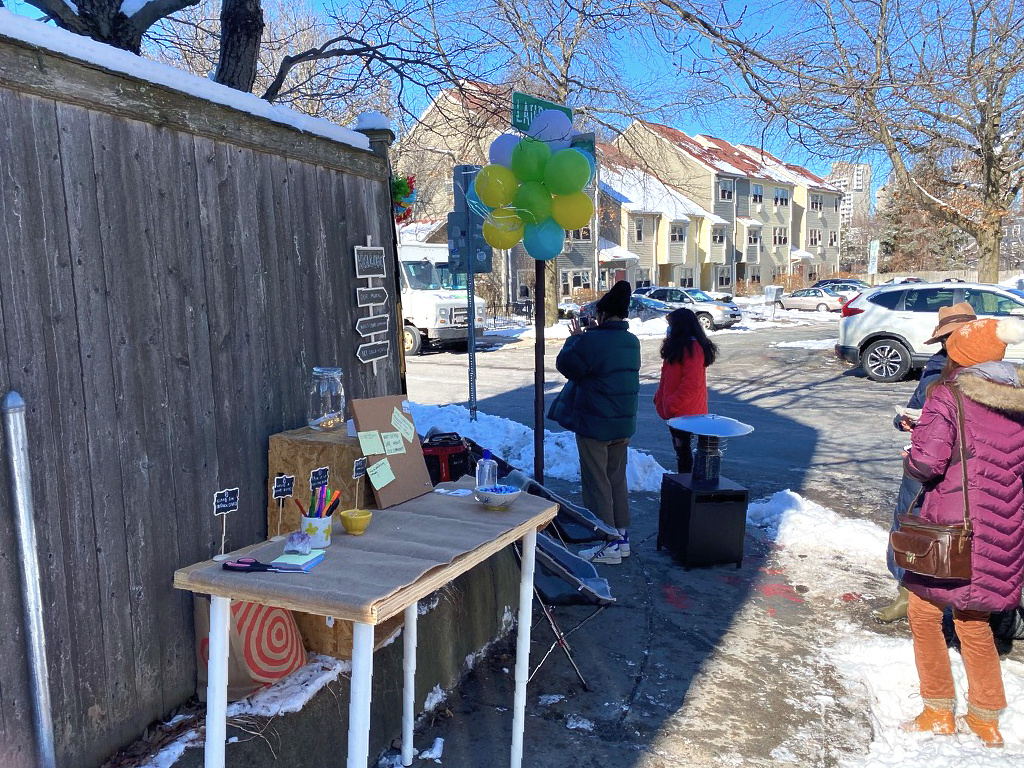 A table and a few chairs on a snowy sidewalk