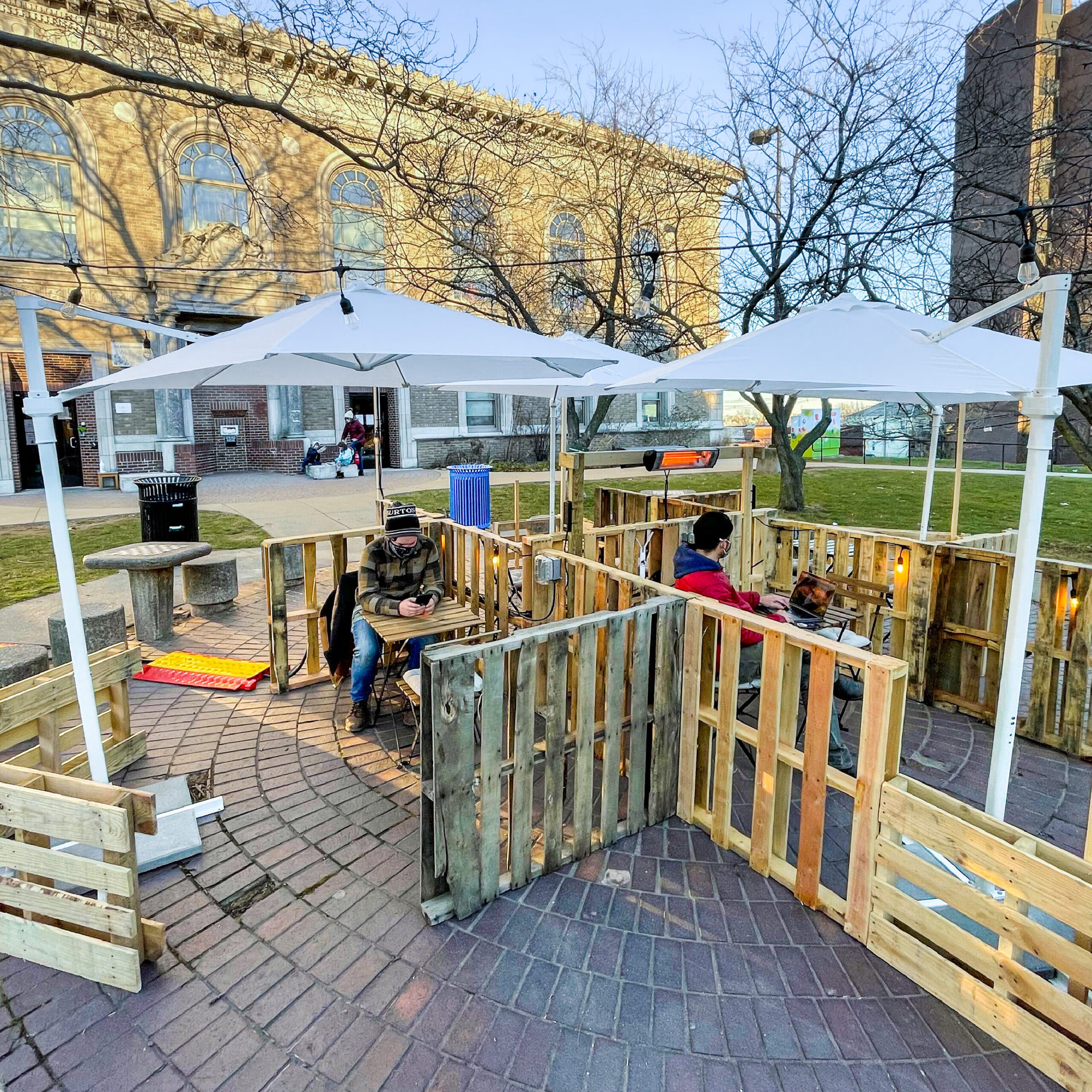 Pallets, umbrellas, and chairs make a outdoor seating area in the courtyard of the Somerville Public Library