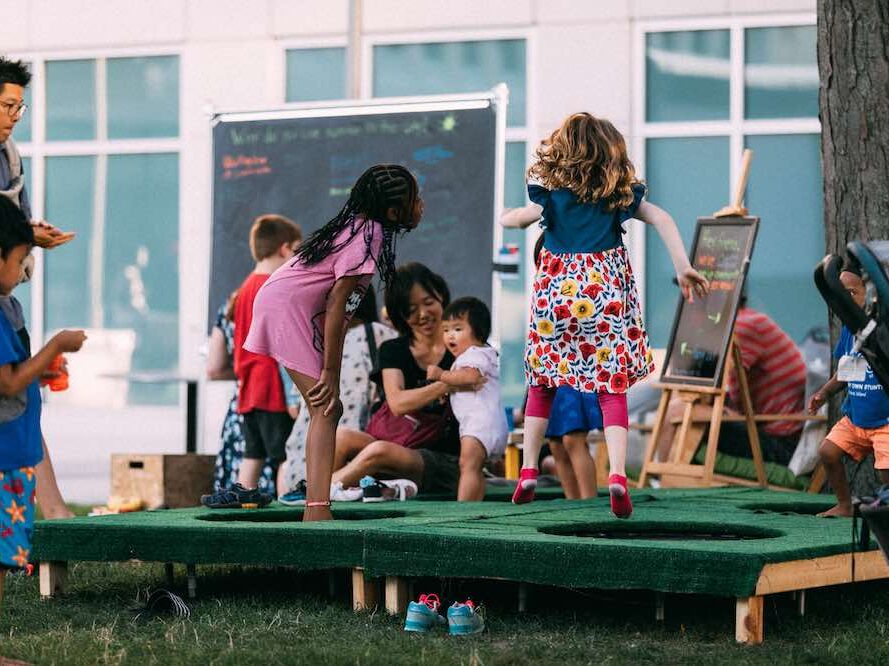 Kids jump on trampolines at a movie night in Technology Square