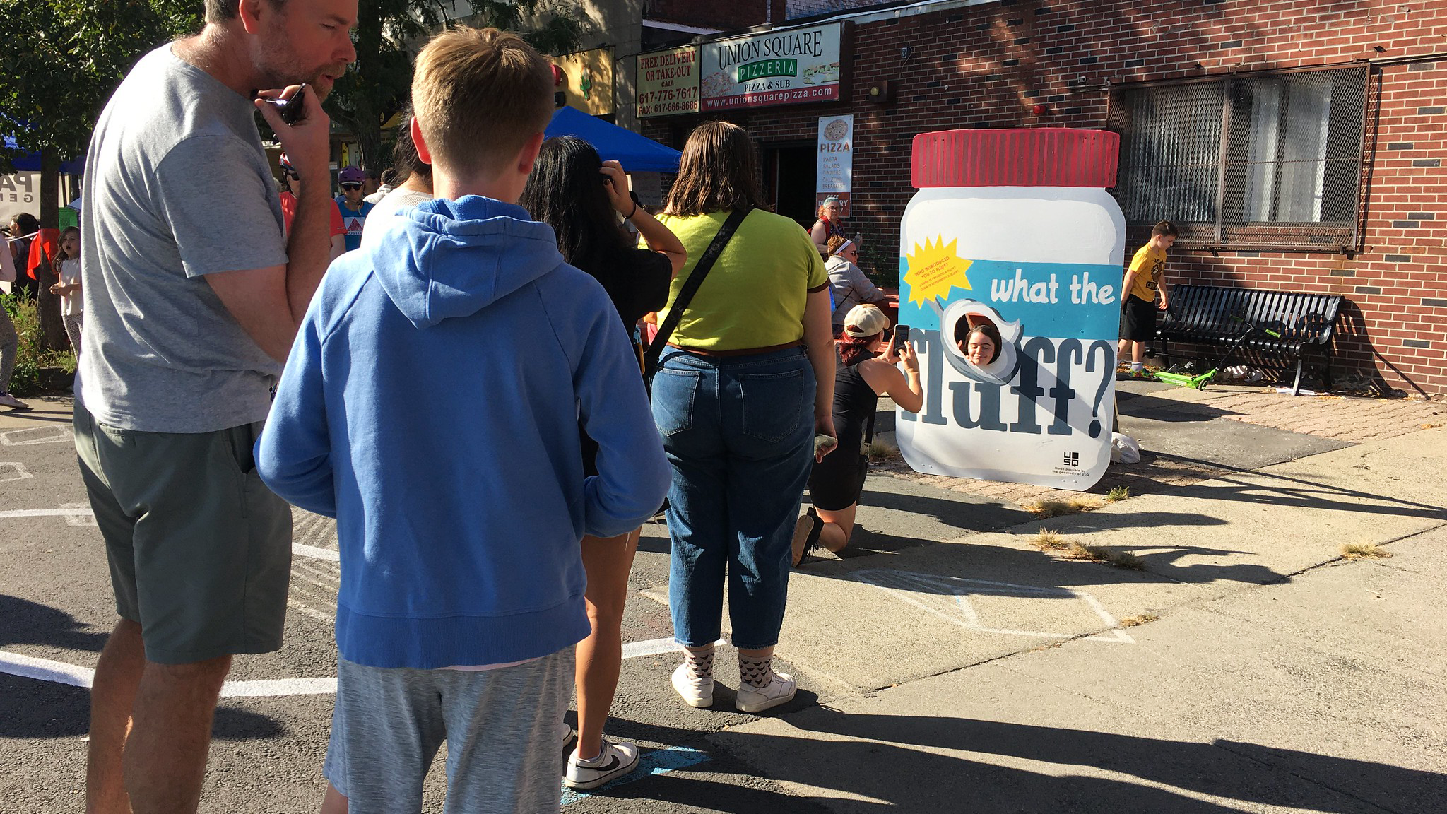 A line of people wait to take photos with a large Fluff Tub