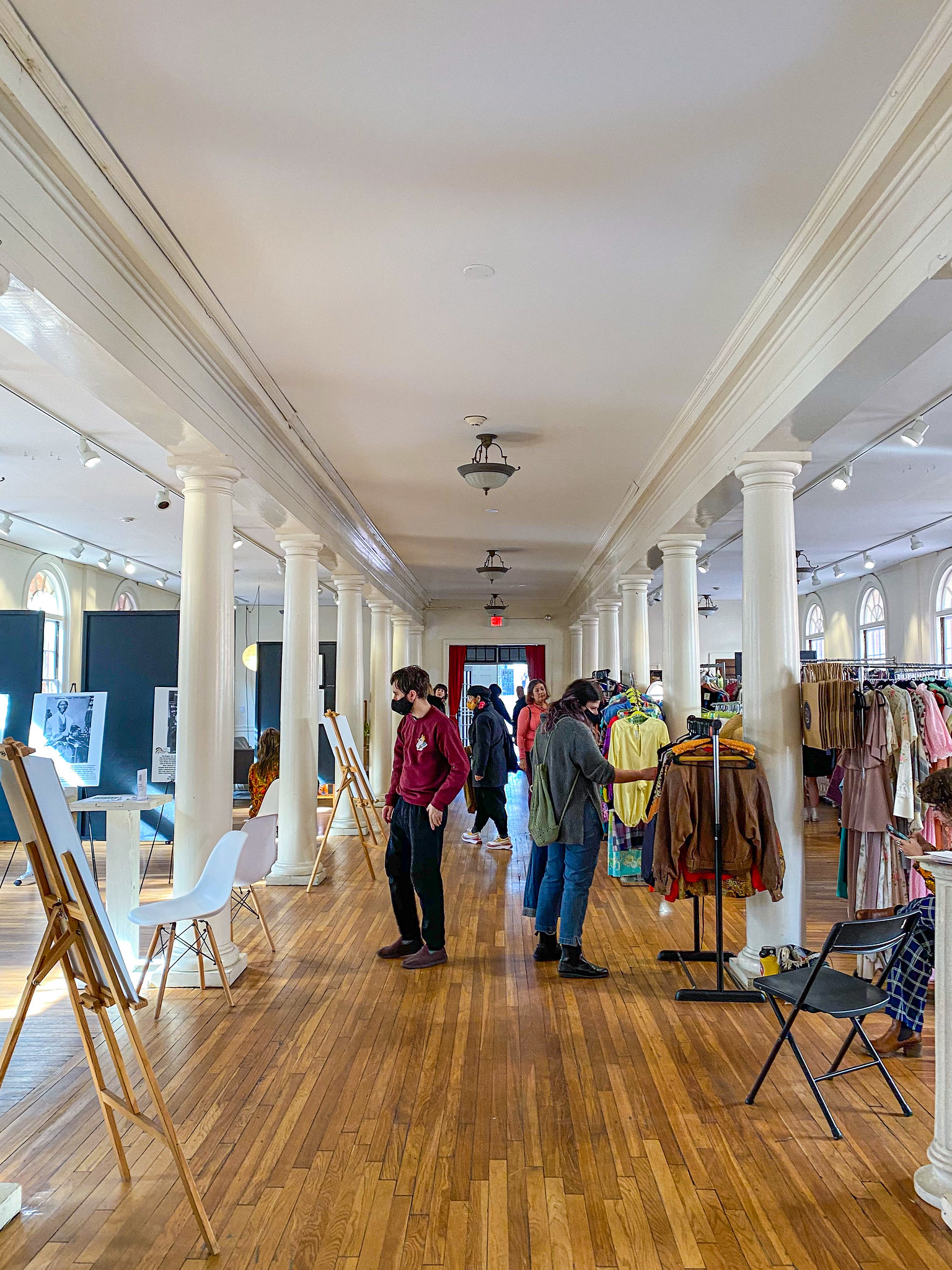 People walk around the Old Town Hall looking at vintage clothing items.