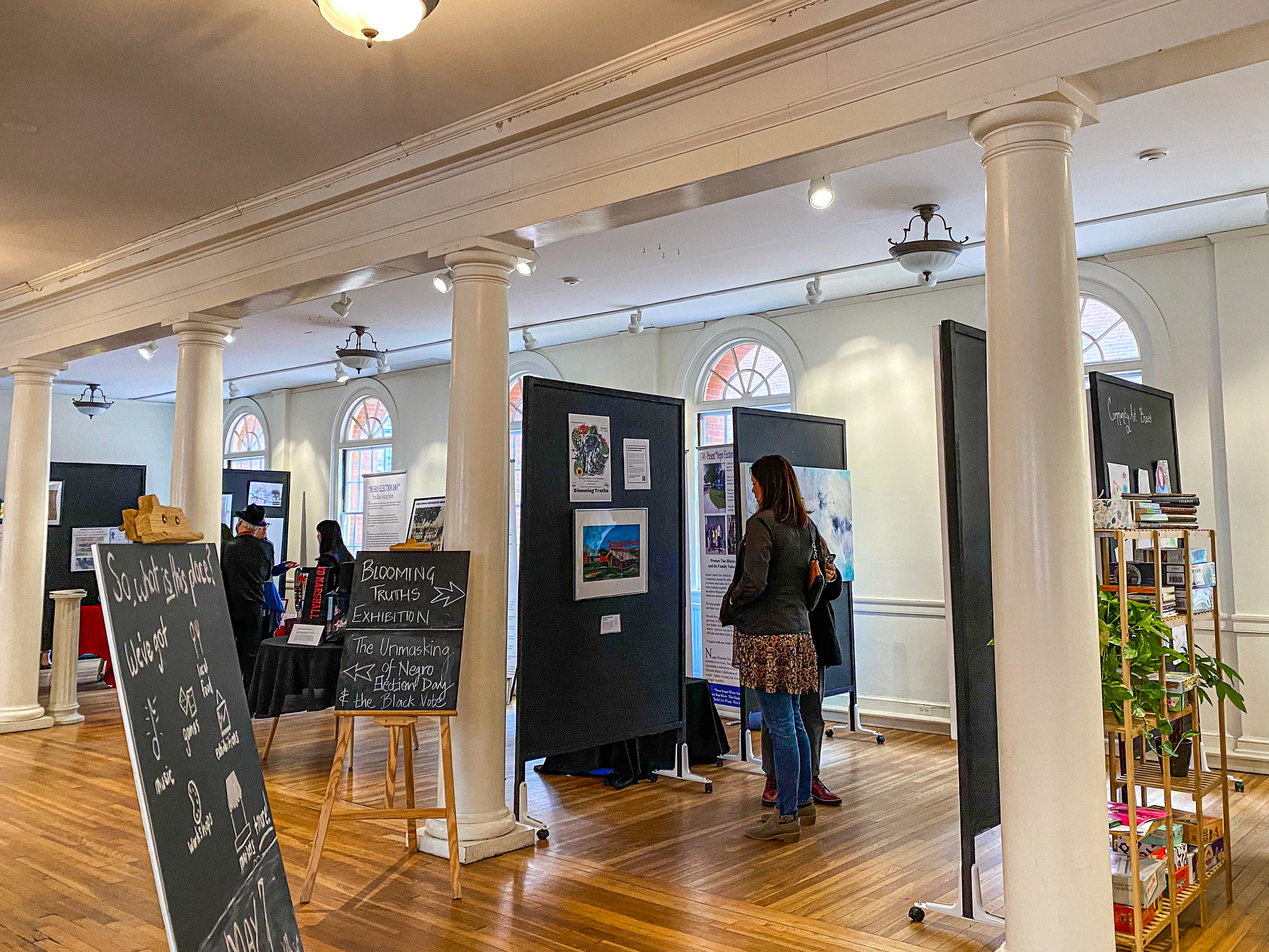 A woman stands looking at framed artworks in the Old Town Hall