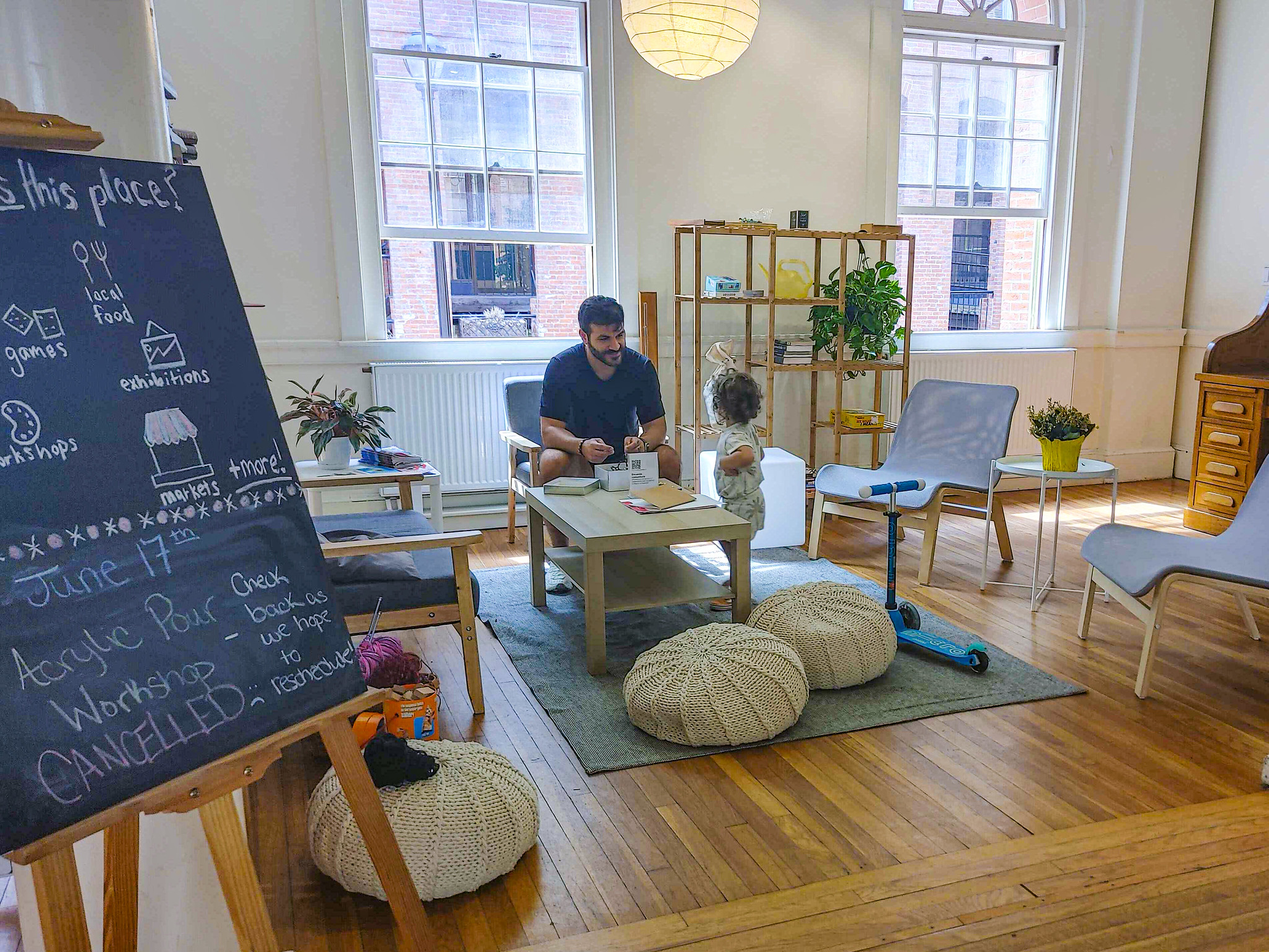 A man and child sit in a living room area playing a game.