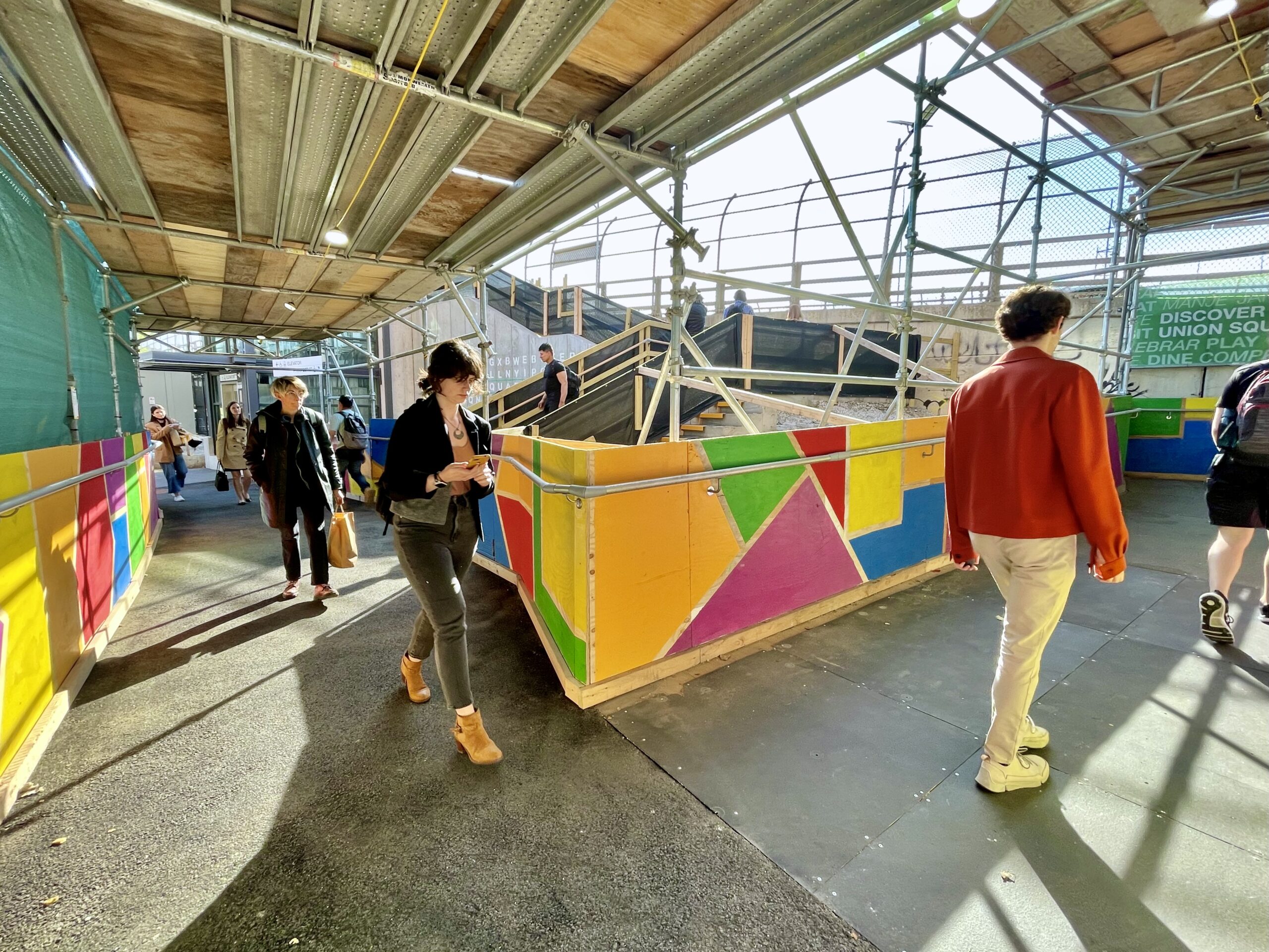 People walk through a brightly-colored walkway.