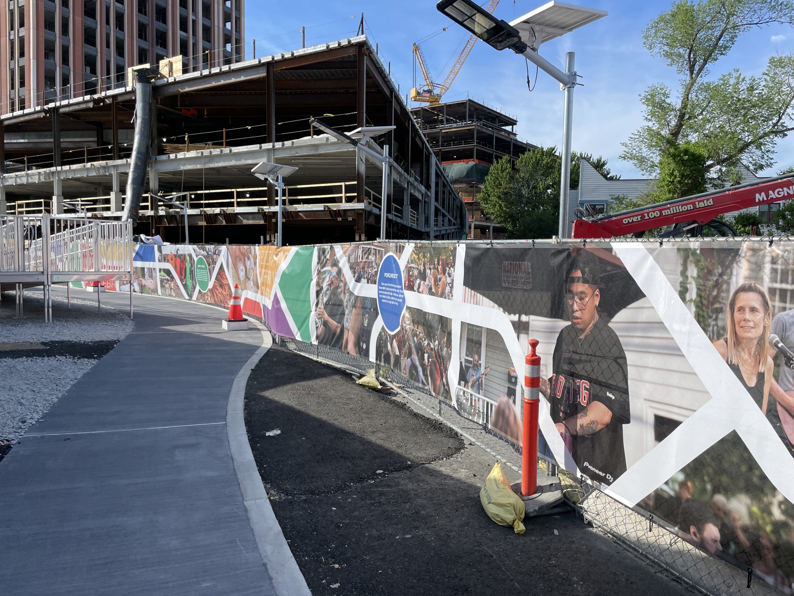 A scrim in front of construction showcasing local artists and creators.