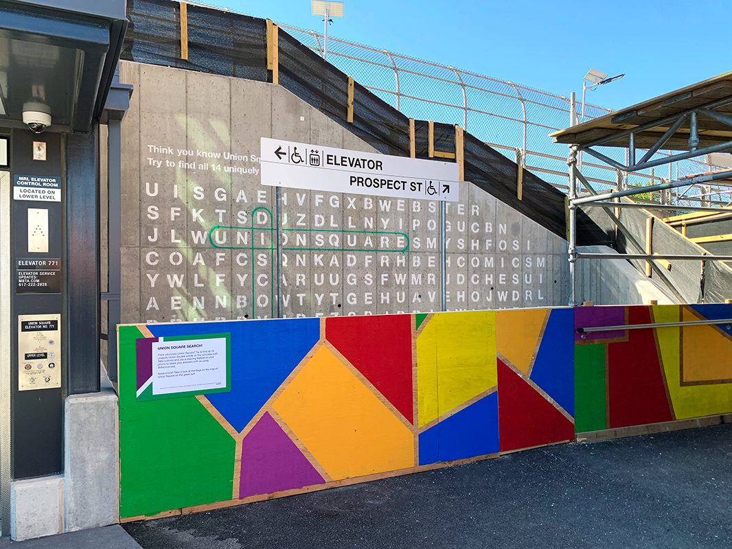 A brightly colored half wall in front of an Union Square themed crossword puzzle.