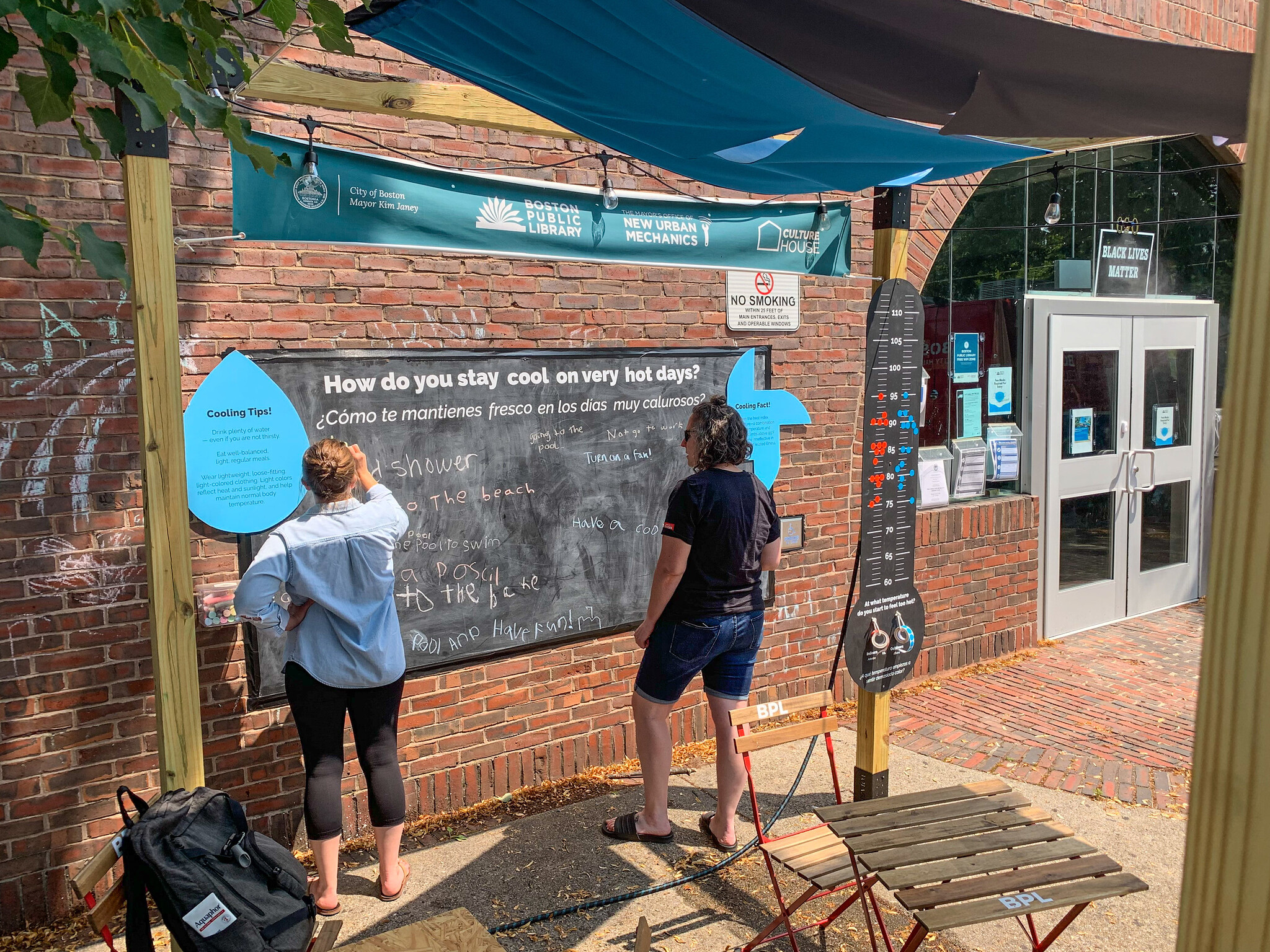 People standing outside in front of a chalkboard asking "how do you stay cool?"