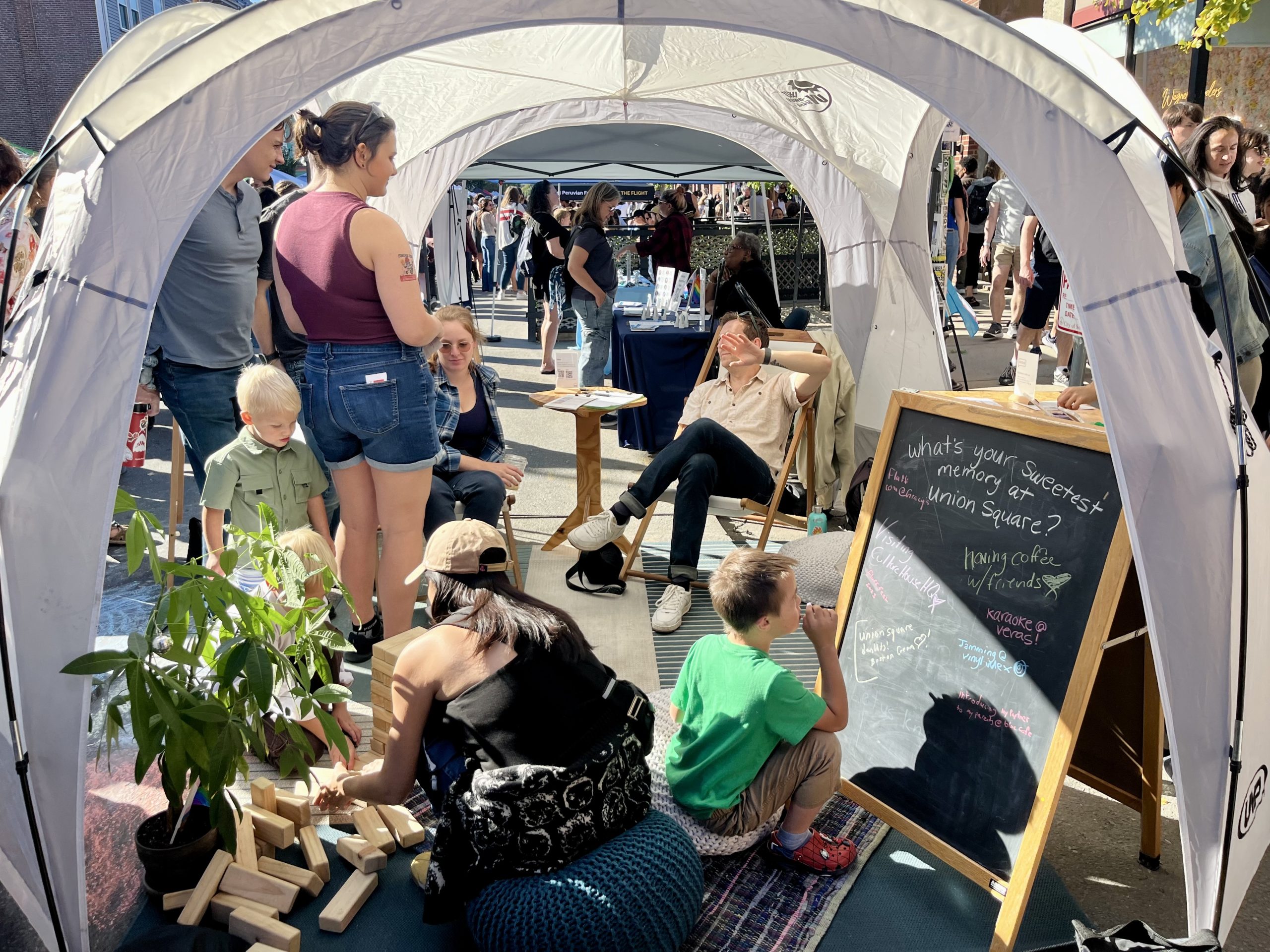 Families hanging out under a tent in our pop-up living room