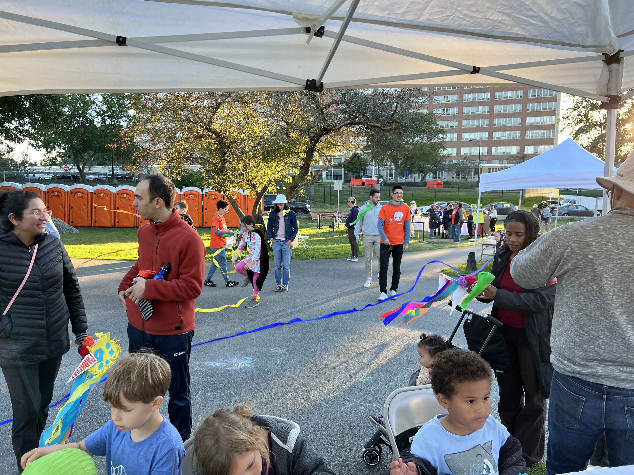 Kids sit at the decorating table or running around with streamers with their parents.