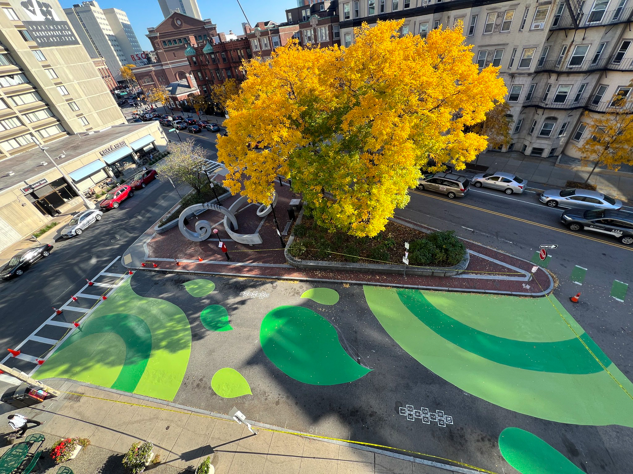 A top down view of a painted street next to a large tree